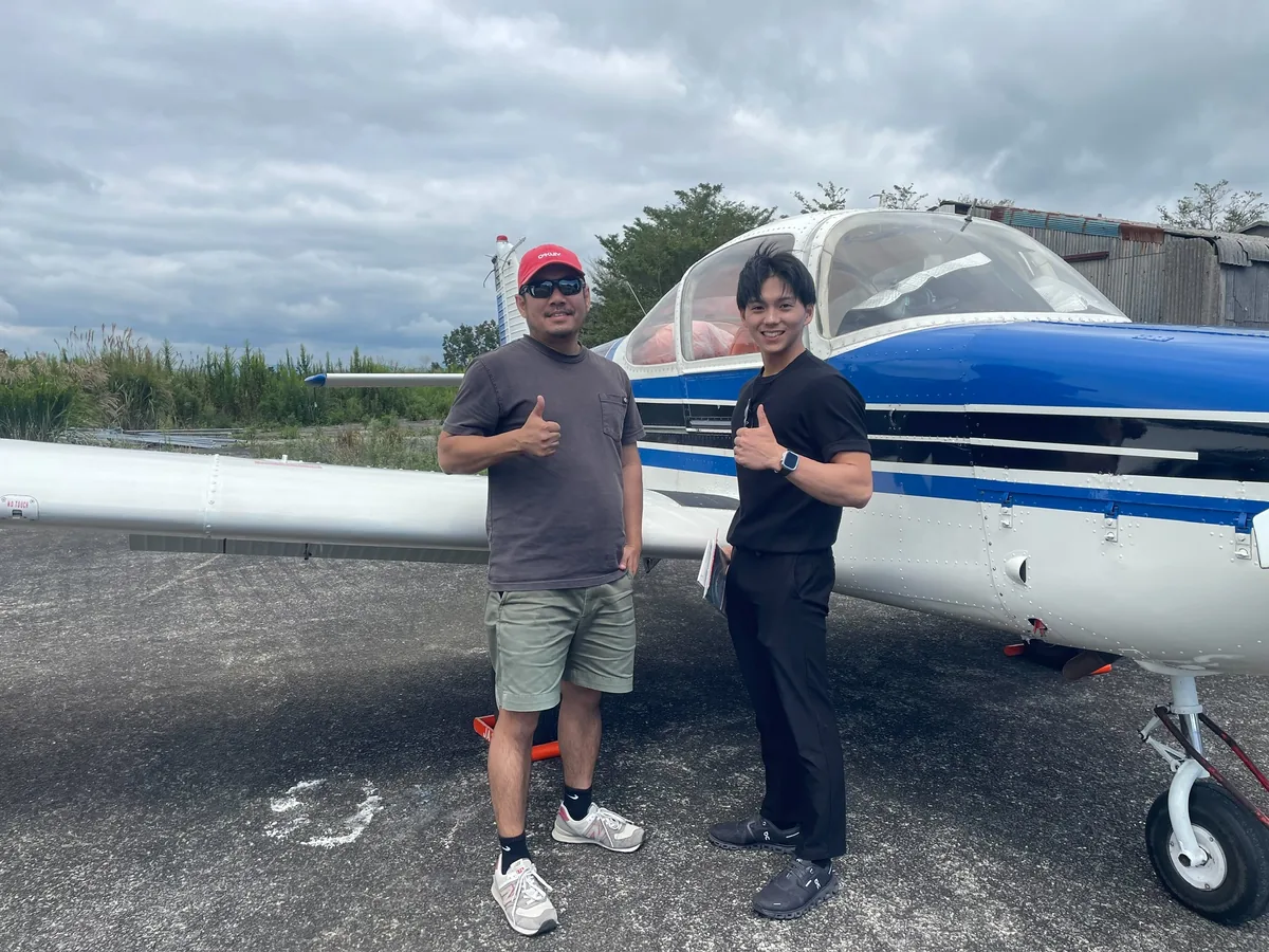 小型機の前で参加者と記念撮影する運営者